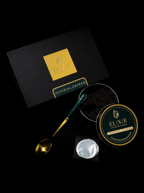 The Imperial Zafran box open on black, its green-lidded tin and a spoon of pearls