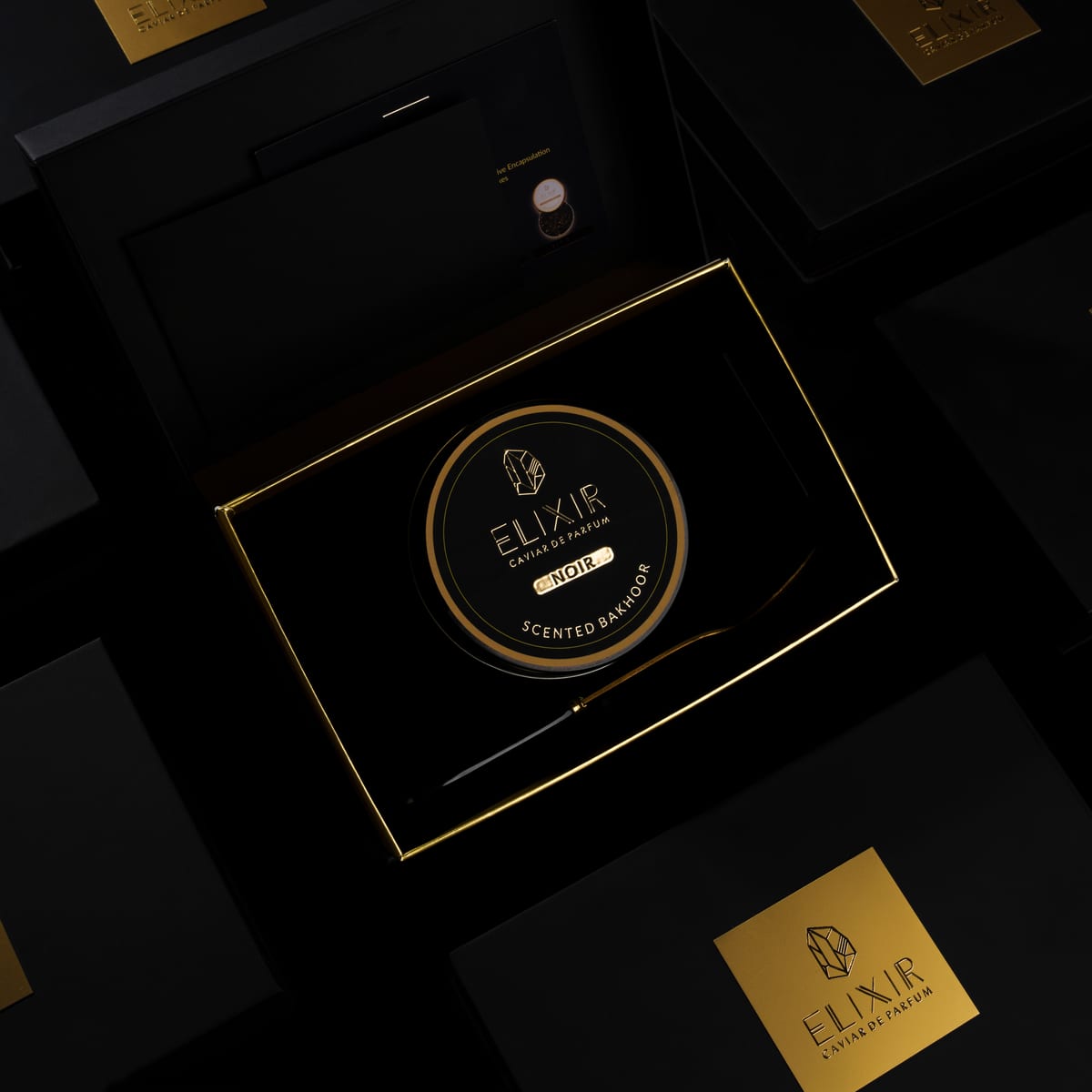 The Noir box open, the tin seated inside beside its gold spoon